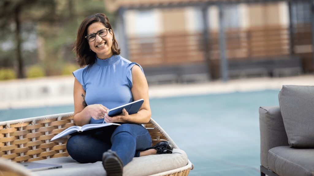 Woman sitting outside working on a tablet computer.