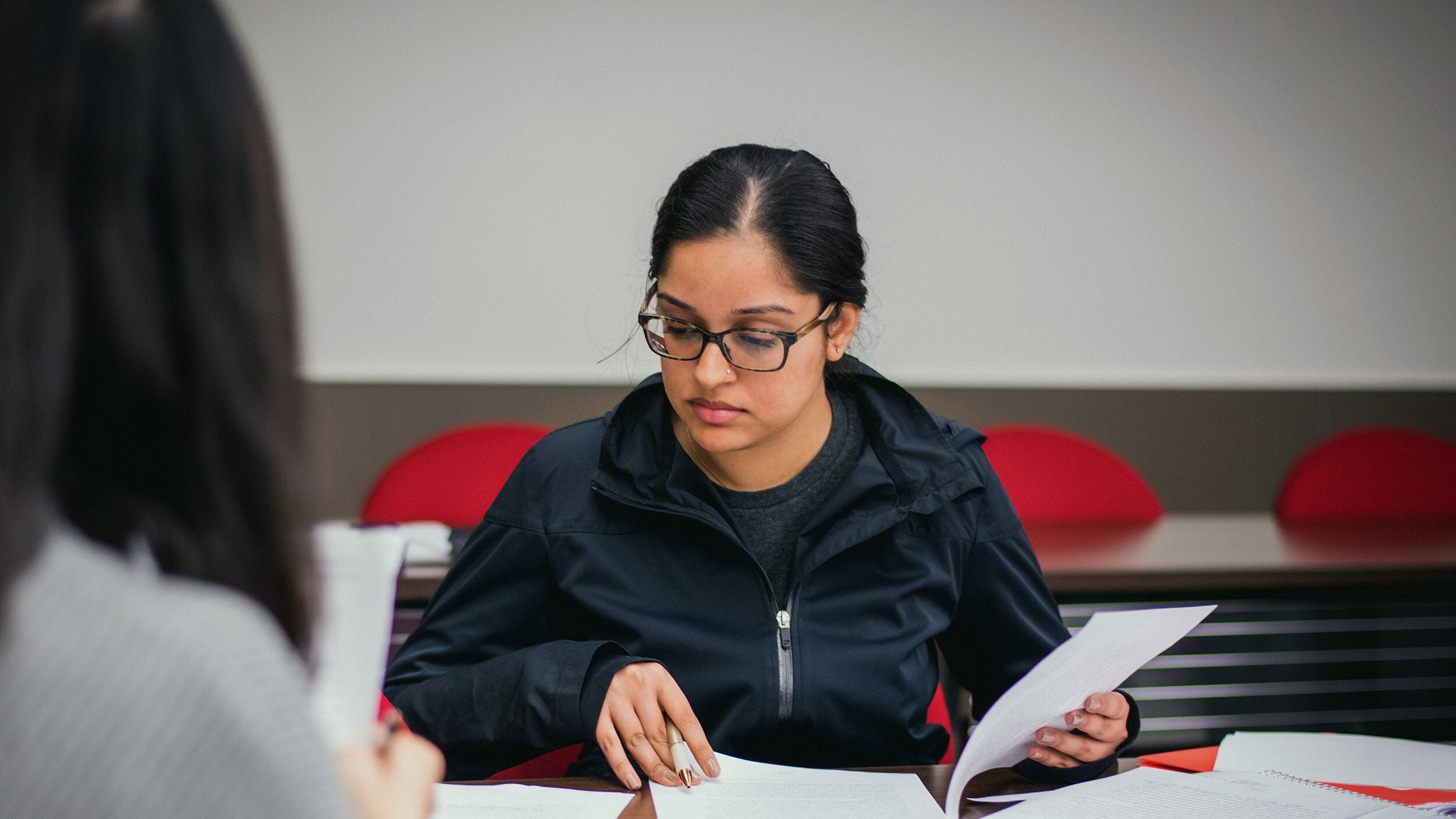 Student in the classroom looking at some papers.