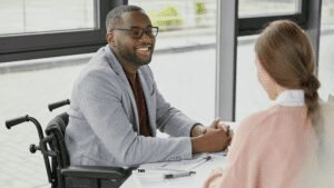 Man sitting at a desk and smiling at a colleague.