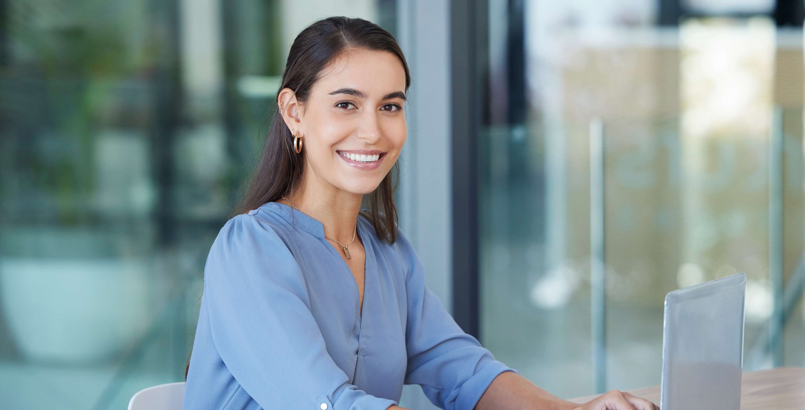 Smiling woman sitting with laptop.