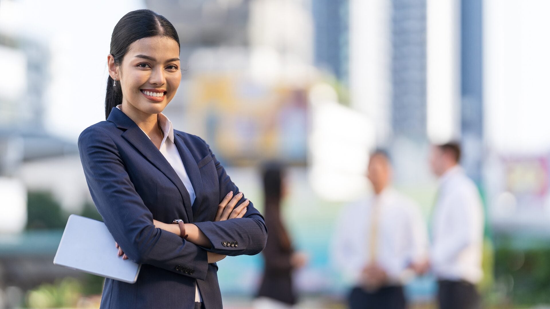 Marketing professional standing with arms crossed.