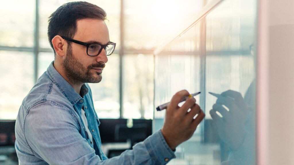 Man writing on a whiteboard.