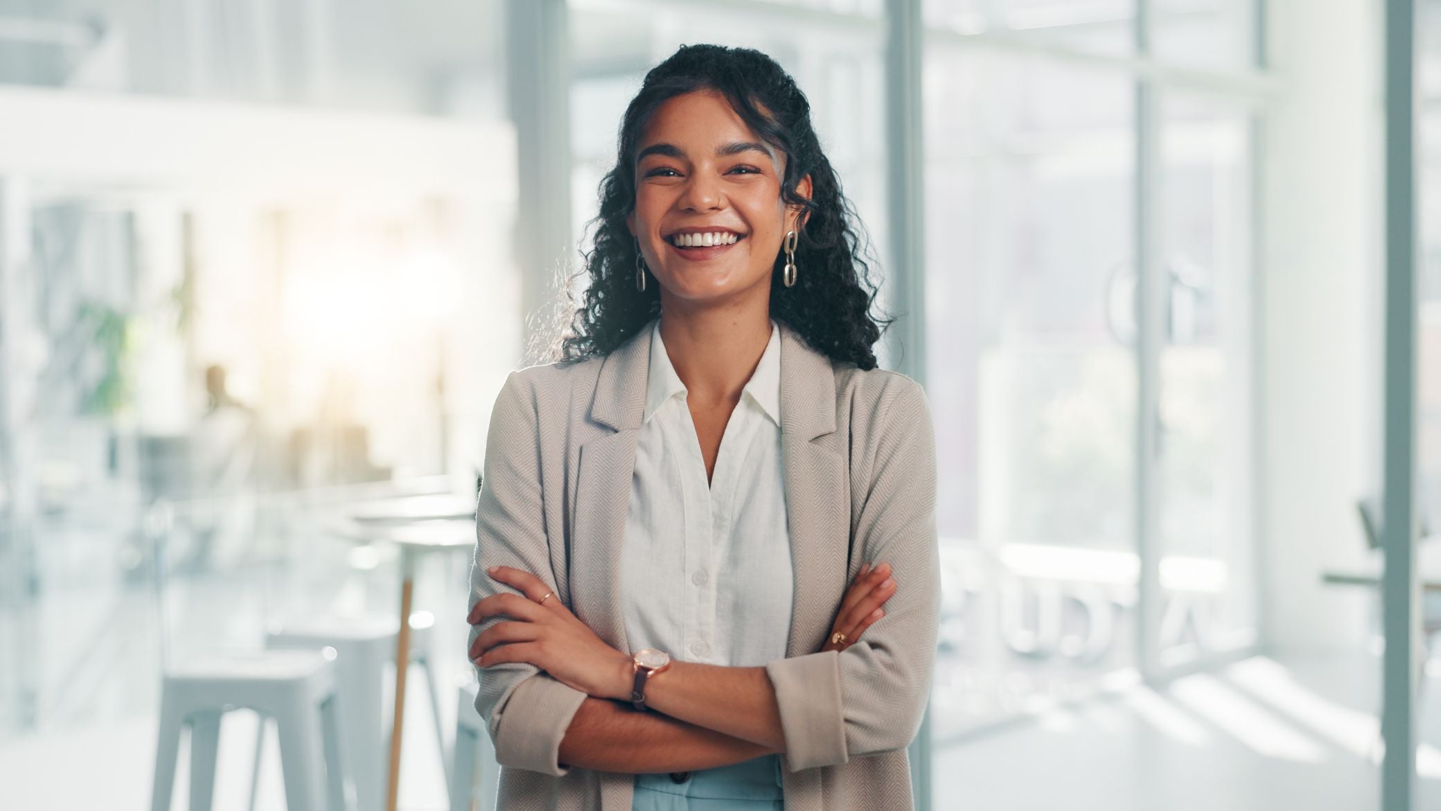 Smiling woman standing with arms crossed.
