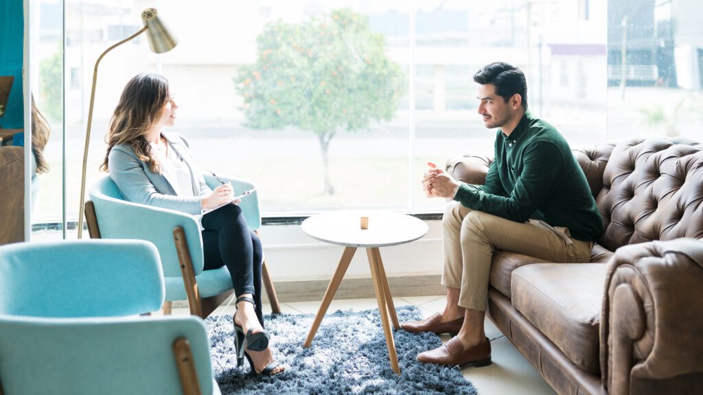 Two people speaking in counselors office.