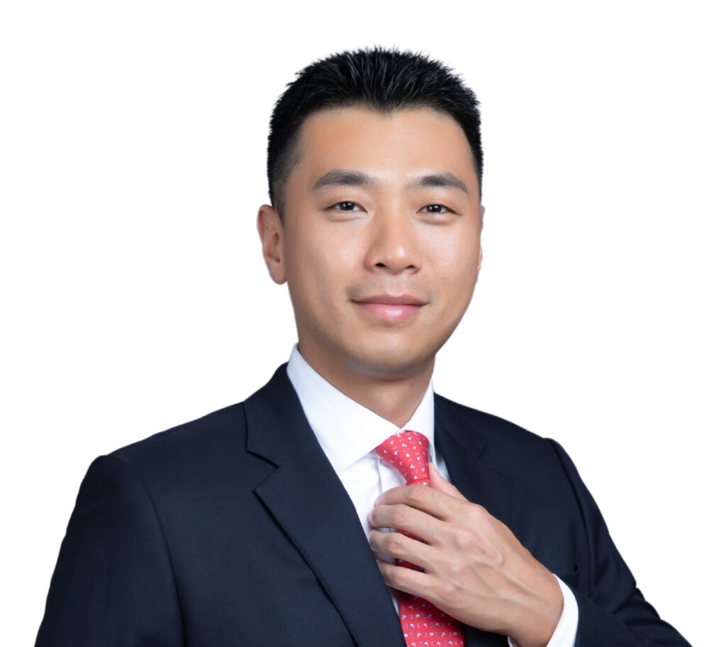 Benson Lu, Board of Trustees, Golden Gate University. A man in a dark suit, adjusting his red-patterned tie against a white background.