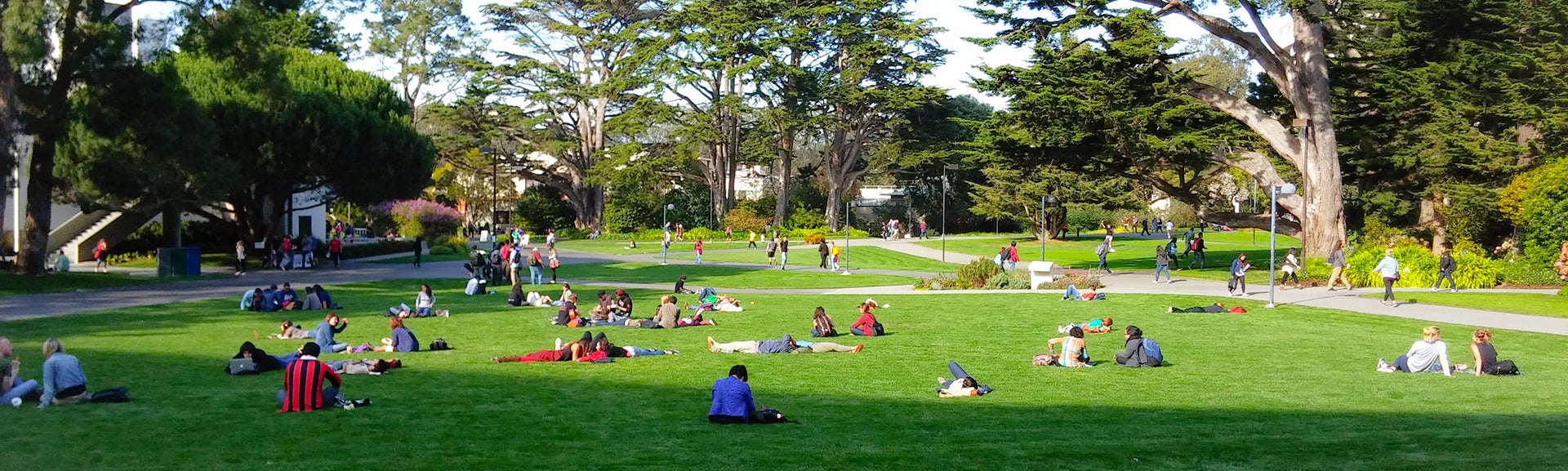 Students relax on the lawn of a quad at GGU's Parkmerced Campus.